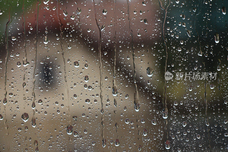 雨点落在窗户上，房子和教堂是背景