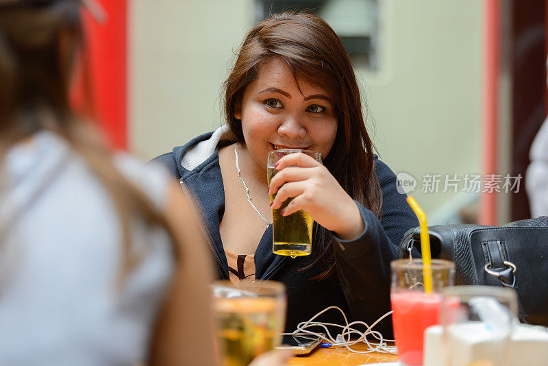 年轻的亚洲女人的肖像在餐厅闲逛和放松