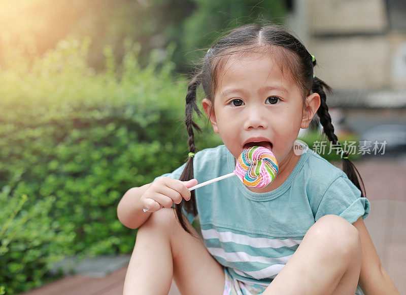 可爱快乐的亚洲小女孩与棒棒糖。
