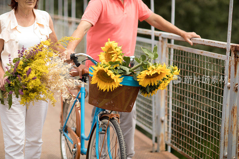 一对老年夫妇在人行桥上骑自行车