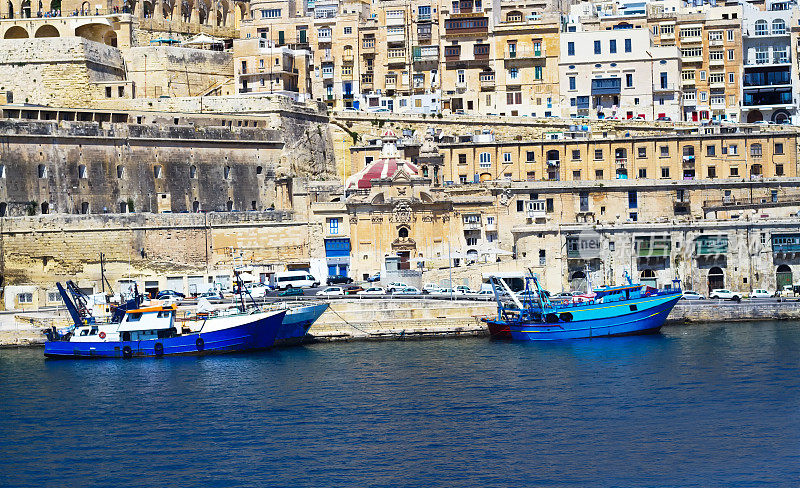 马耳他瓦莱塔:蓝色的渔船和城市景观
