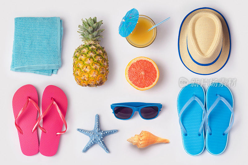热带夏季度假概念菠萝，果汁和拖鞋组织在白色的背景。从以上观点。平躺