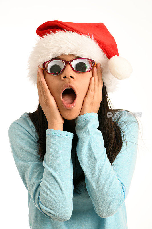 圣诞惊喜!带着大眼睛和圣诞帽的女孩