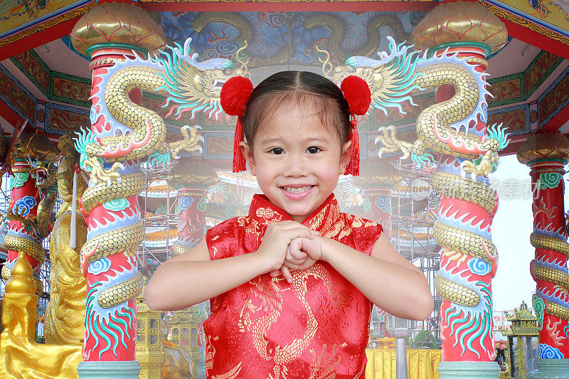 身穿旗袍的亚洲女孩对中国传统新年节日的尊重。