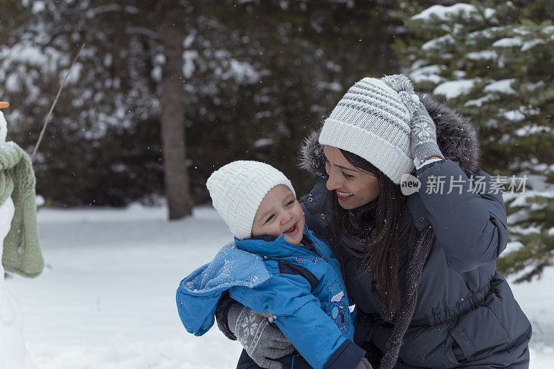 爸爸和妈妈带着他们的孩子，在雪里玩。