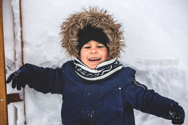 可爱的孩子躺在雪地里