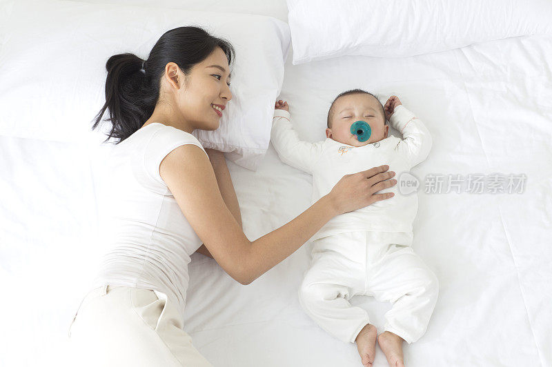 年轻妈妈看着熟睡的宝宝