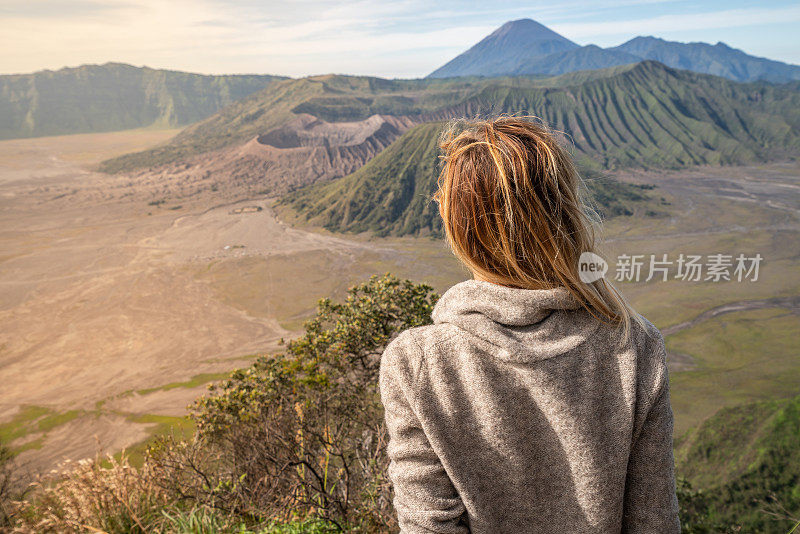 年轻女子徒步旅行沉思火山景观从山顶看布罗莫火山-人们旅行冒险的概念