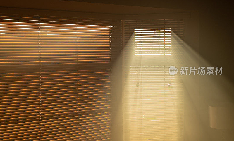 阳光透过百叶窗照进烟雾弥漫的房间