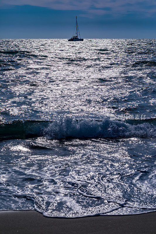 帆船，海浪，海滩和背光