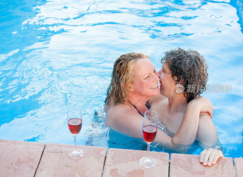 一对浪漫的夫妇在游泳池里享受着放松的沐浴