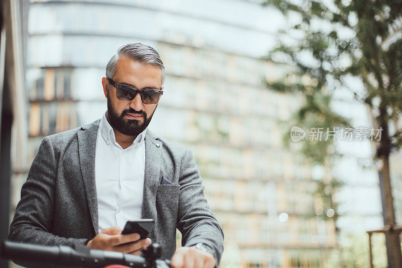 优雅的男子骑着他的电动滑板车在大城市