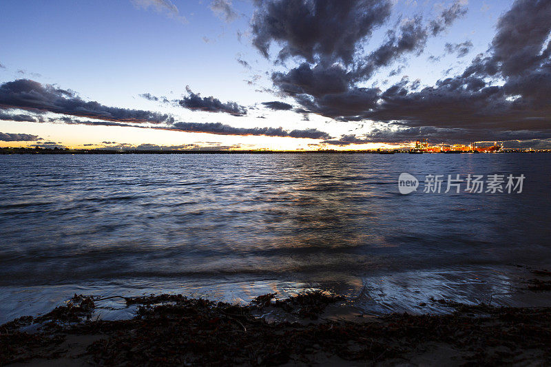 海湾夜间与油船在远处的炼油厂港口，背景与拷贝空间