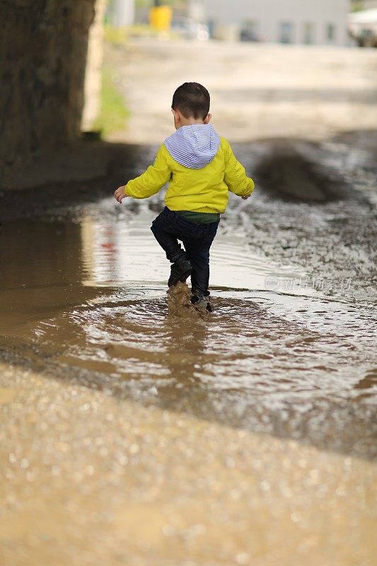 孩子们在雨坑里玩耍