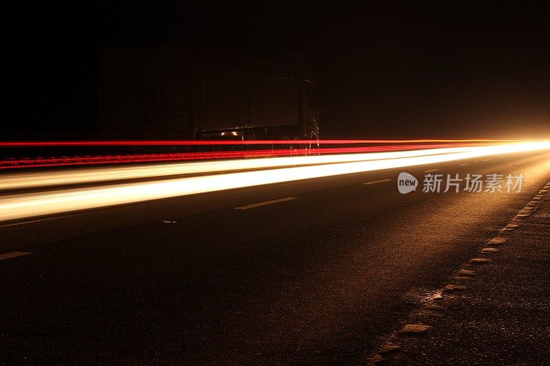 影像光流效果摄影技术，长曝光照片的头和尾灯行驶在双车道在晚上