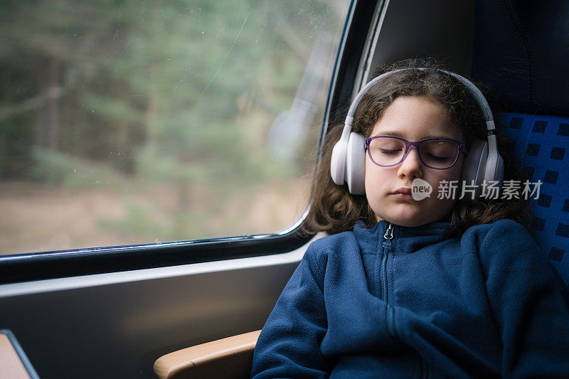 可爱的小女孩喜欢坐火车和听音乐