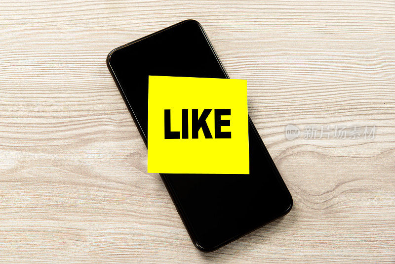 注意与Like字和纸智能手机概念在蓝色背景。社交媒体和数字营销概念。股票的照片……