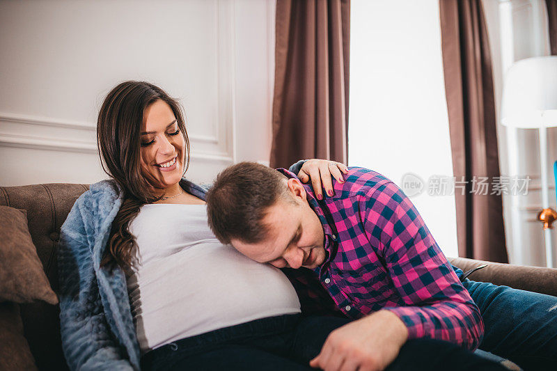 丈夫抚摸着怀孕的妻子的肚子
