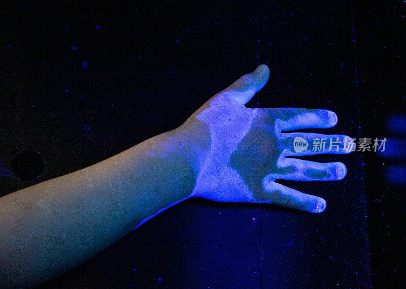 孩子的手在紫外线下暴露出唯一被正确消毒的部分