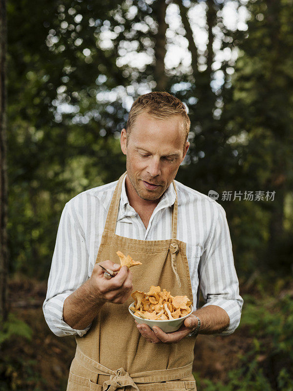 男男厨师在户外用鸡油菌和煎锅