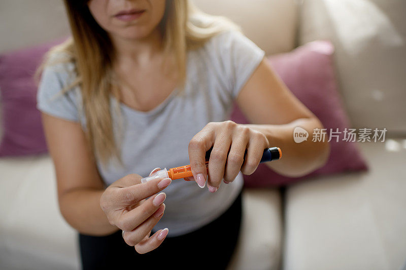 年轻的糖尿病妇女用胰岛素笔
