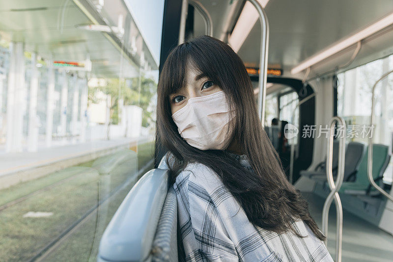 年轻女子在乘坐地铁时使用智能手机