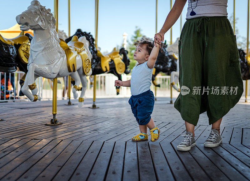 男婴第一次骑旋转木马