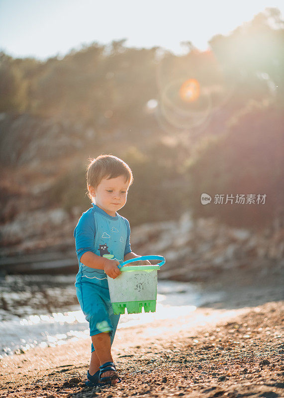 小男孩在海里玩玩具桶