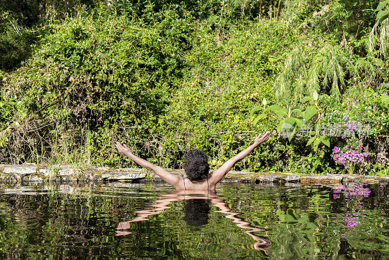 湖中一位非洲拉丁妇女向大自然张开双臂