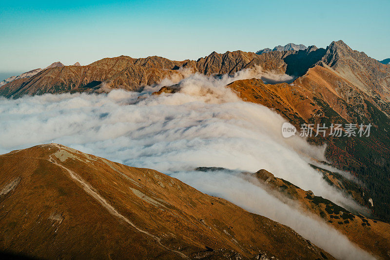 塔特拉山脉和日落的秋景。云朵飘浮于山峰之上