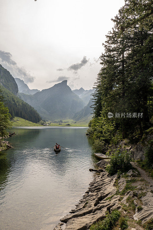 日落时美丽的高山湖泊，阳光照在山脊上，反射在水面上