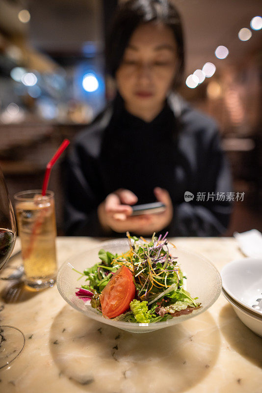 在餐厅用智能手机的女人