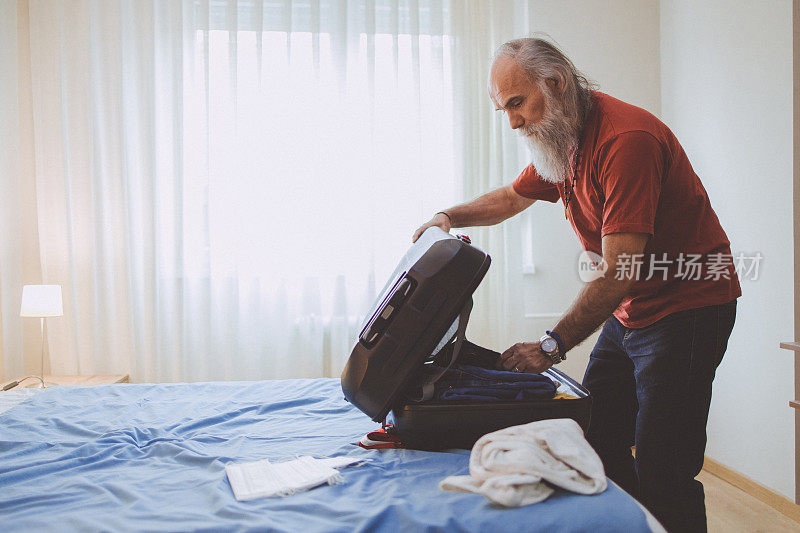 一个成熟的男人在收拾行李准备旅行
