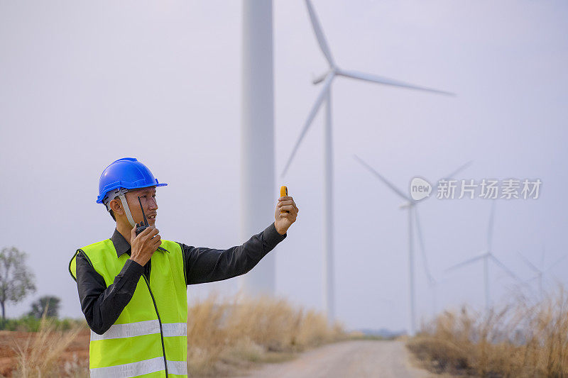 电力工地的蓝领工人。风车。