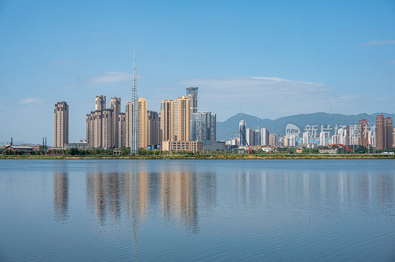 清澈的湖水映衬出现代城市的天际线