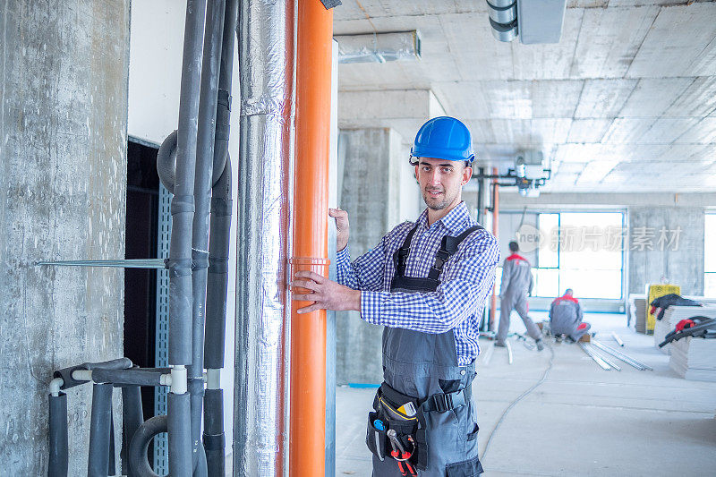 欢快的建筑工人在施工现场用大型平整机检查结构