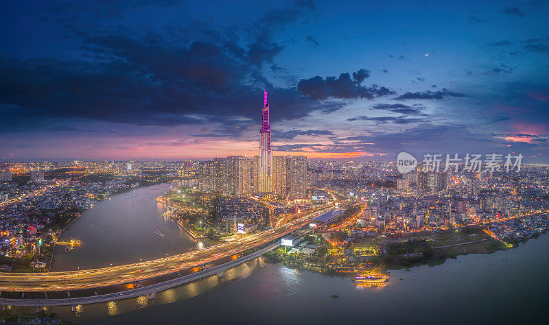 从空中俯瞰81号地标的日落景观——一幢超高的摩天大楼和西贡大桥，西贡河沿岸的发展在光线下十分流畅