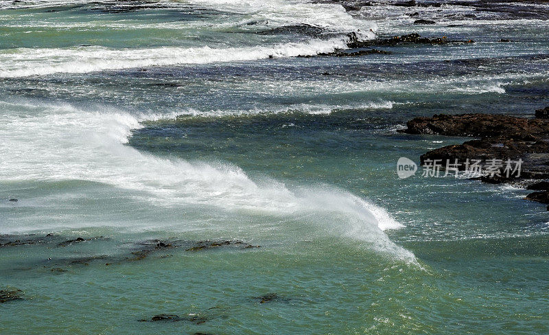 从上面和后面看一个破碎的海浪，强风从海浪的顶部吹来。南国,新西兰。