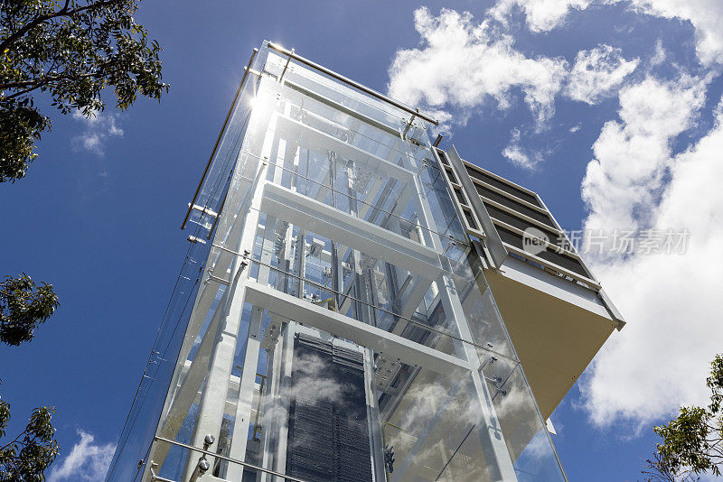 现代户外玻璃电梯，低角度视野，背景与复制空间