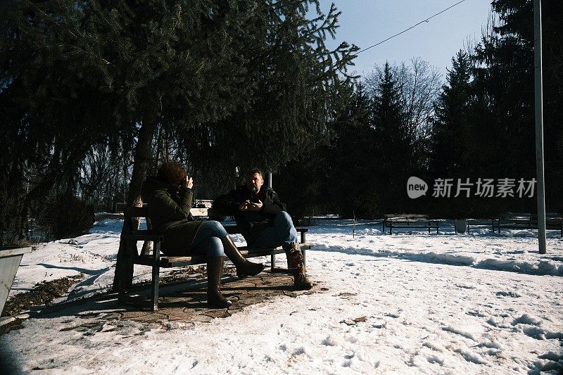 女子在冬季公园给男子拍照
