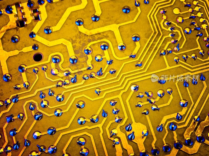 金色电路痕迹在电脑主板背面焊点突出蓝色照明