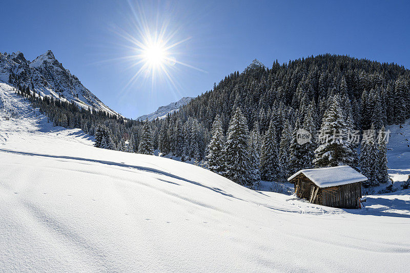 冬天的风景，有一个古老的小屋和雪山