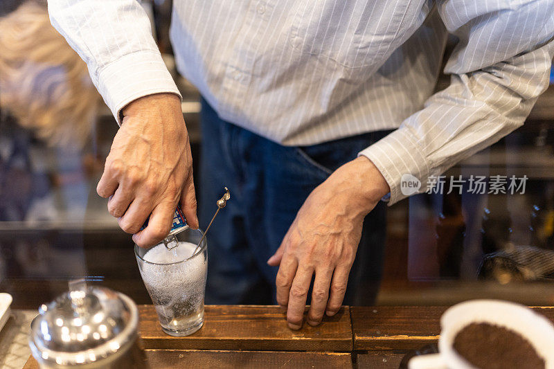 一位老人在他的咖啡馆里调饮料