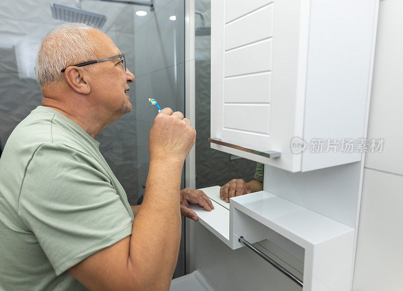 成熟男人在浴室镜子前刷牙