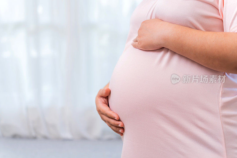 亚洲孕妇独自在家照顾未出生的婴儿。