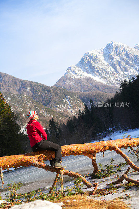 斯洛文尼亚耶泽斯科，一位老妇人坐在普兰萨尔湖边倒下的树上。