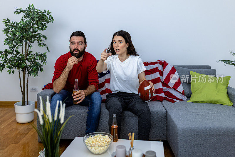 一个年轻人和他的女朋友正在看足球比赛。