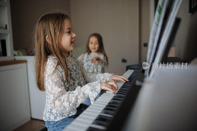 两姐妹一起愉快地练习钢琴