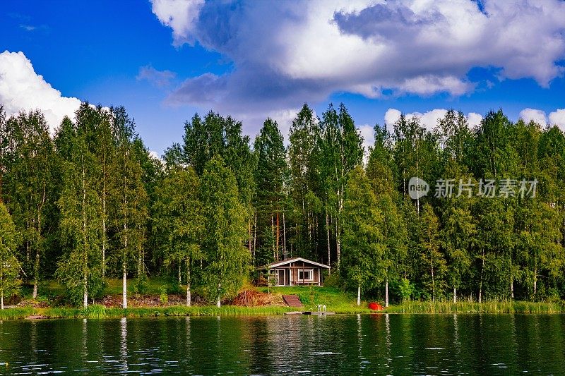 芬兰夏日湖畔的木制桑拿小木屋