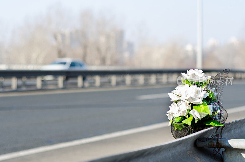 人工白色玫瑰花在一场交通事故的现场与致命的结果。